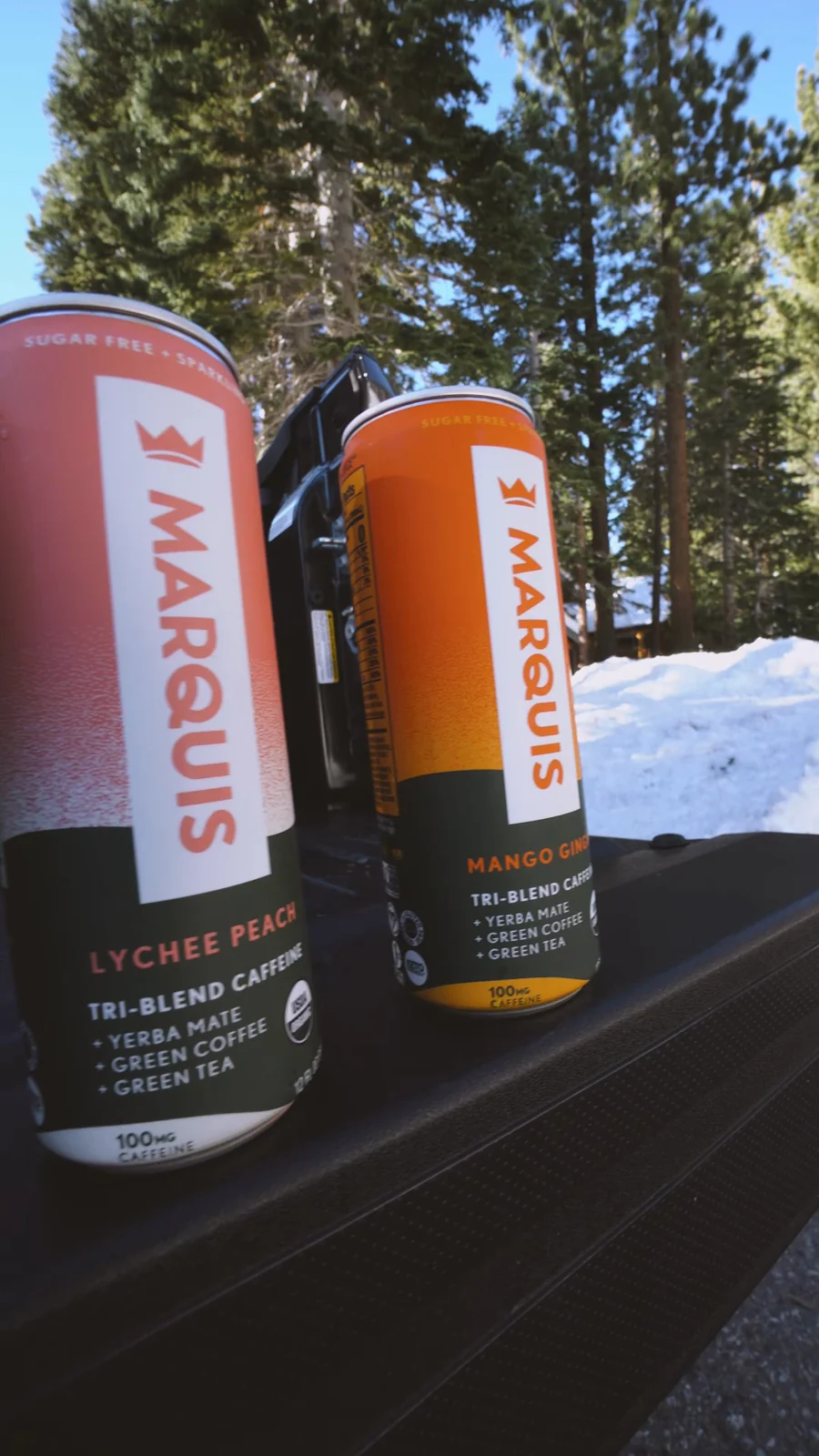 Marquis beverage cans in a snowy mountain setting.